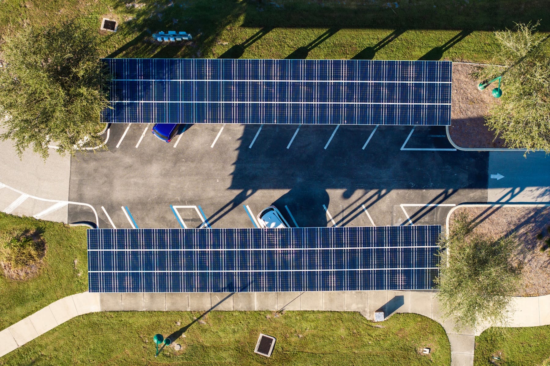 Carport fotowoltaiczny na parkingu firmowym z panelami tworzącymi szczelny dach nad samochodami